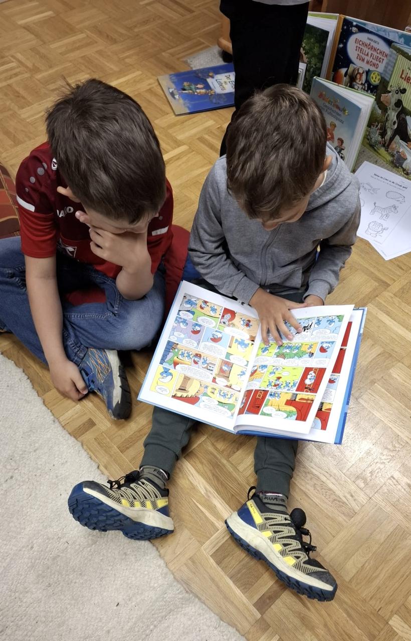 Zwei Kinder lesen Schlumpfbuch